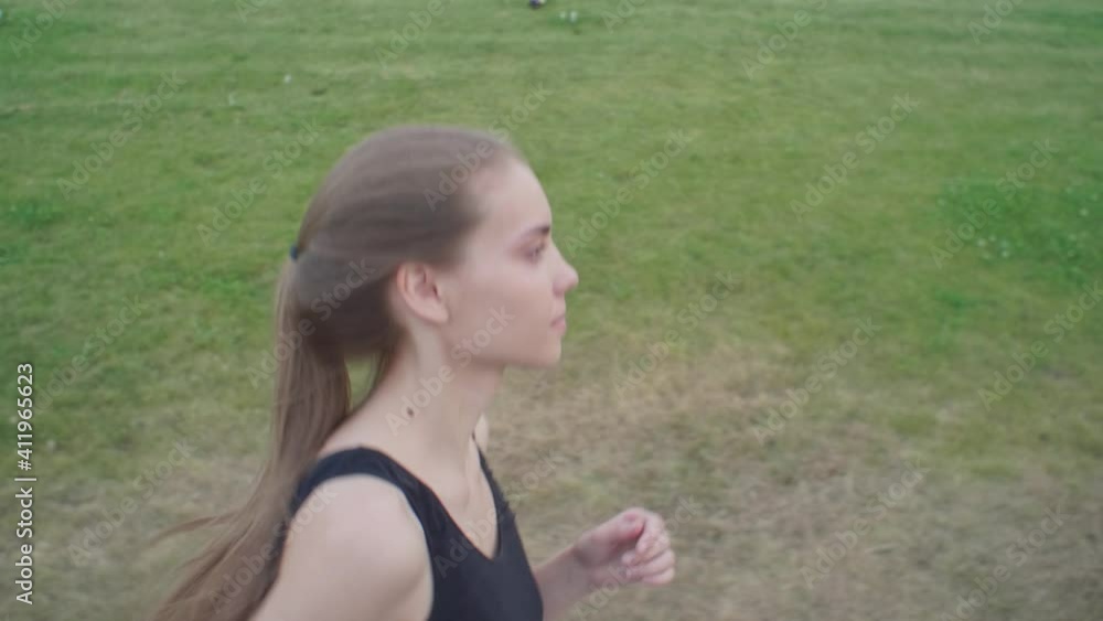 A beautiful girl is jogging in the park. A young woman runs around the park for her health. the concept of sports and rejuvenation. A beautiful girl is jogging in the park. A young woman runs around the park for her health. the concept of sports and rejuvenation.