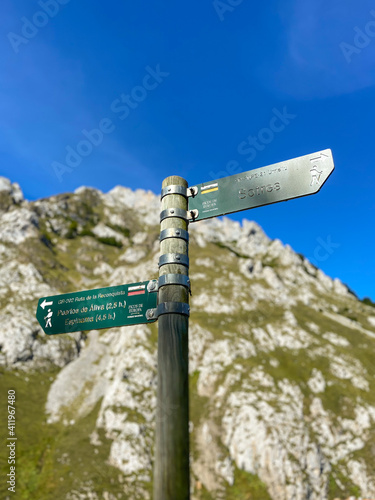 Sotres, Spain - September 3, 2020: Wooden signpost with directional signs on hiking trail in the River Duje valley near Sotres, Picos de Europa, Asturias. photo