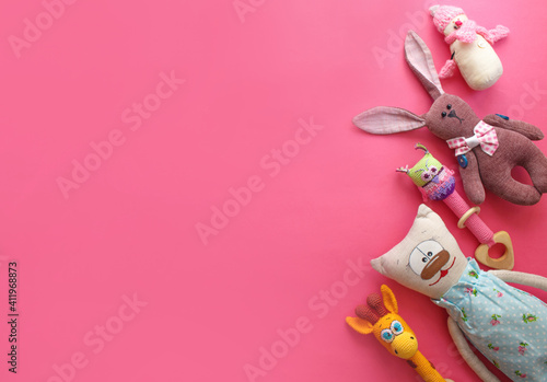 many children's toys are laid out on a pink background top view. space for text