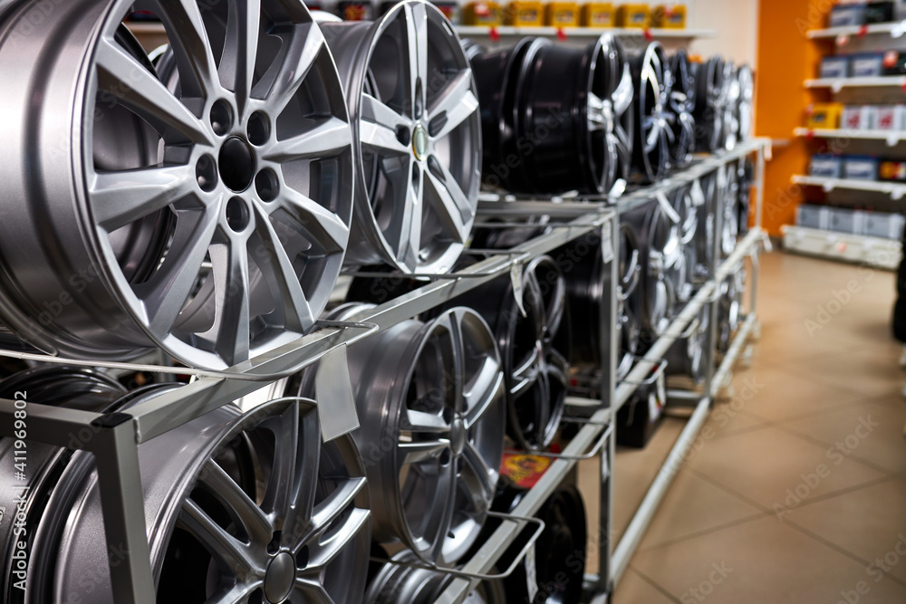modern store with alloy wheels and tires, indoors in shop. a lot of discs for automobile, big assortment modern store with alloy wheels and tires, indoors in shop. a lot of discs for automobile, big assortment