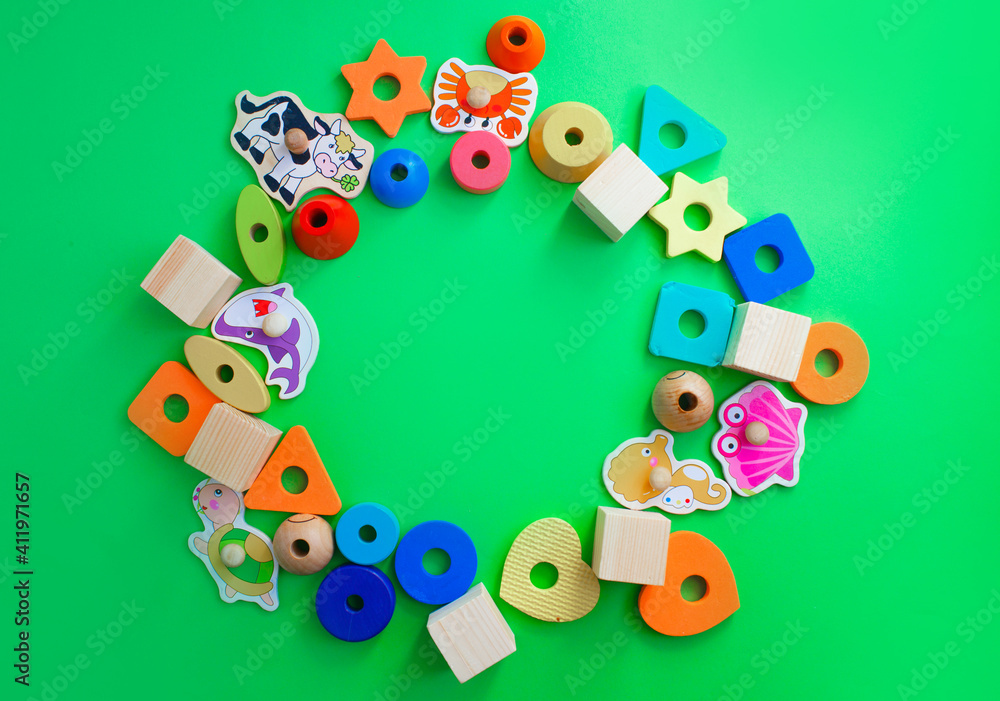 Fototapeta premium children's toys are laid out on a green background top view. space for text