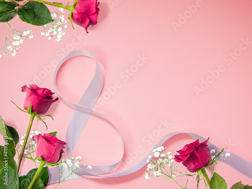 Flower background made of roses with decorative white ribbon with copy space on pink background, happy valentine's day, mother's day, flat lay, top view
