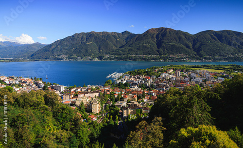 above Locarno city switzerland during summer season with blue sky and sun, green trees beautiful hdr colorful