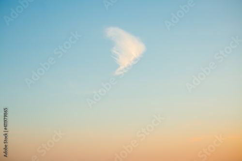 Picturesque view of single white cloud on blue sky background in daytime.