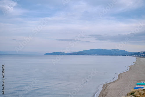 Beach, shore of marmara sea in Mudanya and small  fishing boats on the sand of beach together with small hill background during close and overcast weather.