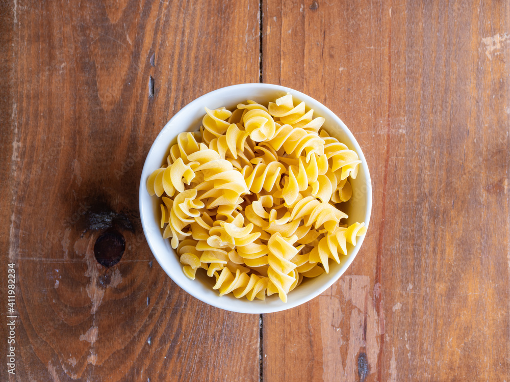 Top view of fusilli giganti in bowl on wood table. High resolution