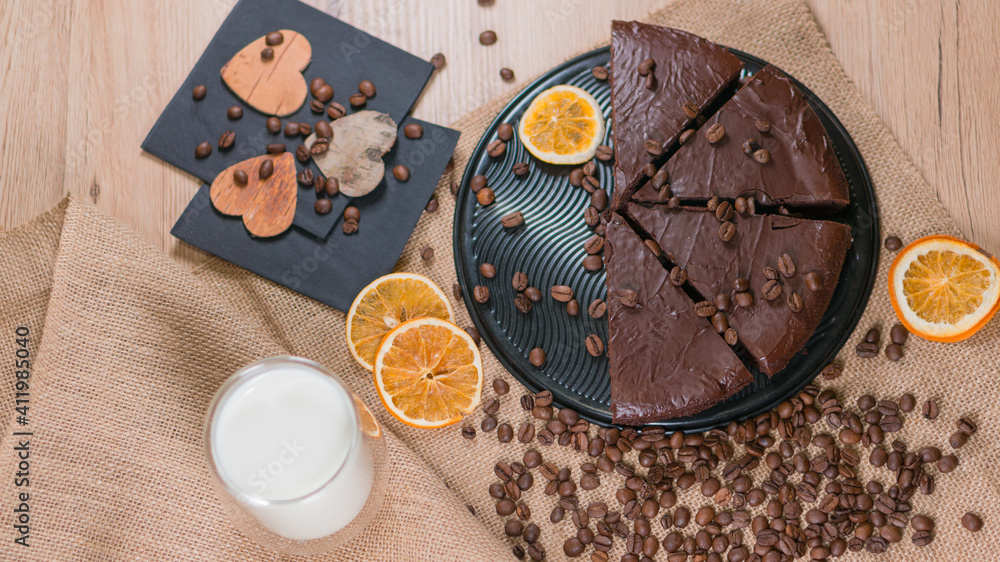 slices of chocolate brownie cake with glass of milk and coffee beanas on wooden table