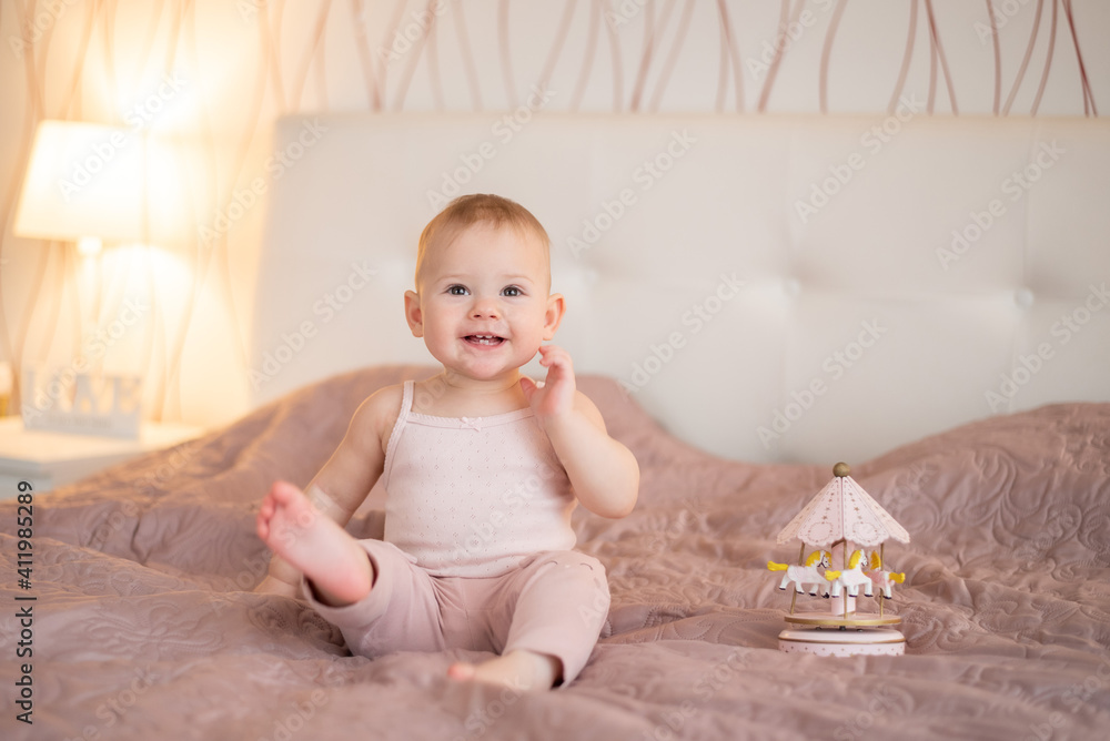 cute happy 1 year old baby girl playing with wooden toys at home. Modern nursery interior, early learning concept cute happy 1 year old baby girl playing with wooden toys at home. Modern nursery interior, early learning concept