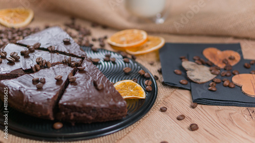 slices of chocolate brownie cake with glass of milk and coffee beanas on wooden table photo