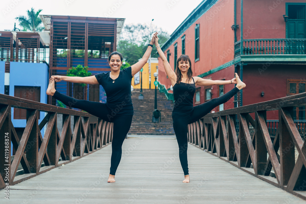 Latin women on bridge practicing yoga. Padangusthasana