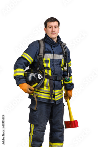 Young brave man in uniform of fireman holds axe and hardhat in his hands and looking at camera isolated on white background