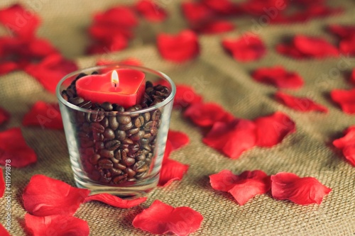 Valentine’s red candle and rose petals