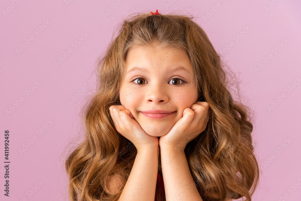A little girl on a purple background looks ahead. A little girl on a purple background looks ahead.