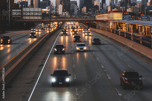 City skyline and cars driving along freeway at sunset, Chicago, Illinois, USA
