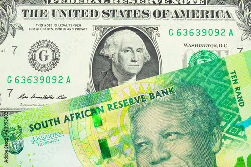 A macro image of a shiny, green 10 rand bill from South Africa paired up with a green one dollar bill from the United States.  Shot close up in macro.