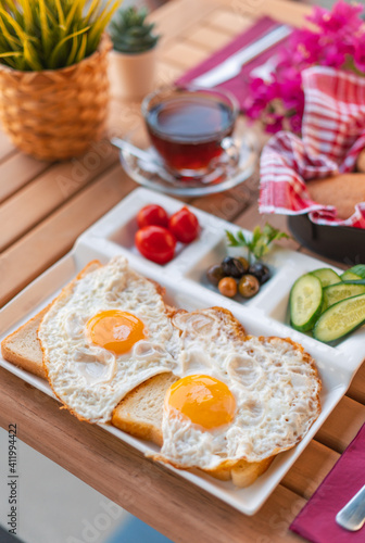 Fried eggs sunny side up on bread with side dishes. Breakfast of sunny side up eggs. Weekend breakfast concept with sunny side up eggs