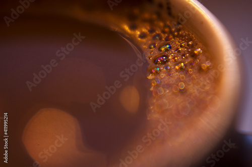macro coffee with milk and raindow bubbles - selective focus with copy space, warm colorful background