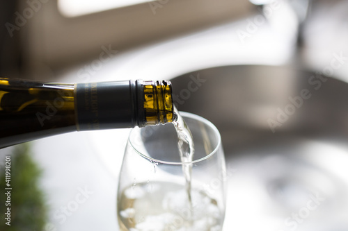 Wine bottle and glass on kitchen bench