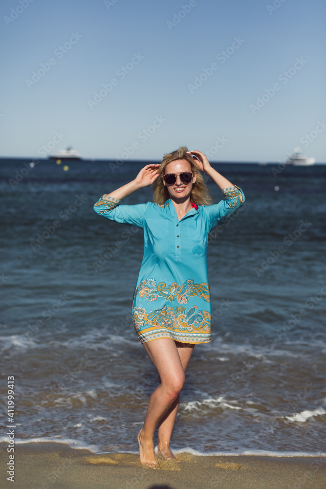 The happy young woman is standing by the ocean