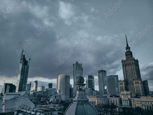 WARSAW, POLAND - February 05, 2021: Beautiful panoramic aerial drone view on Warsaw City Skyscrapers, PKiN, and Varso Tower under construction and 19th-century tenement houses during the sunset