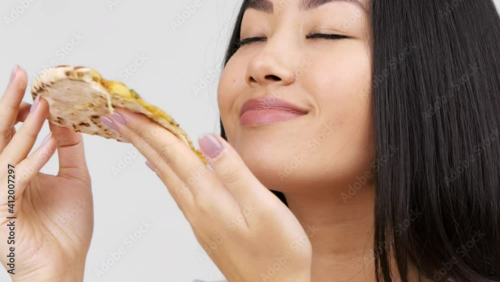 Japanese Young Lady Eating Hot Pizza Enjoying Taste, White Background Japanese Young Lady Eating Hot Pizza Enjoying Taste, White Background