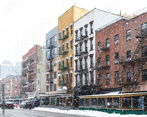 Photography Winter street scene with snowing blowing over the buildings along Avenue A in th