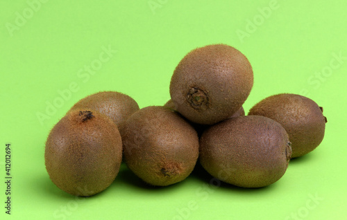 A pile of Kiwi fruit on a lime green background