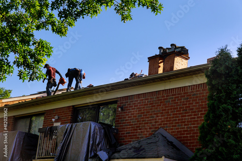 Construction worker on renovation roof the house installed new shingles