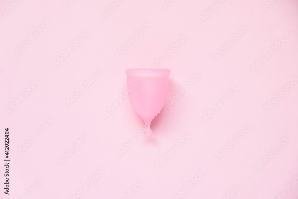 Menstrual cup on pink background. Alternative feminine hygiene product during the period. Women health concept Menstrual cup on pink background. Alternative feminine hygiene product during the period. Women health concept