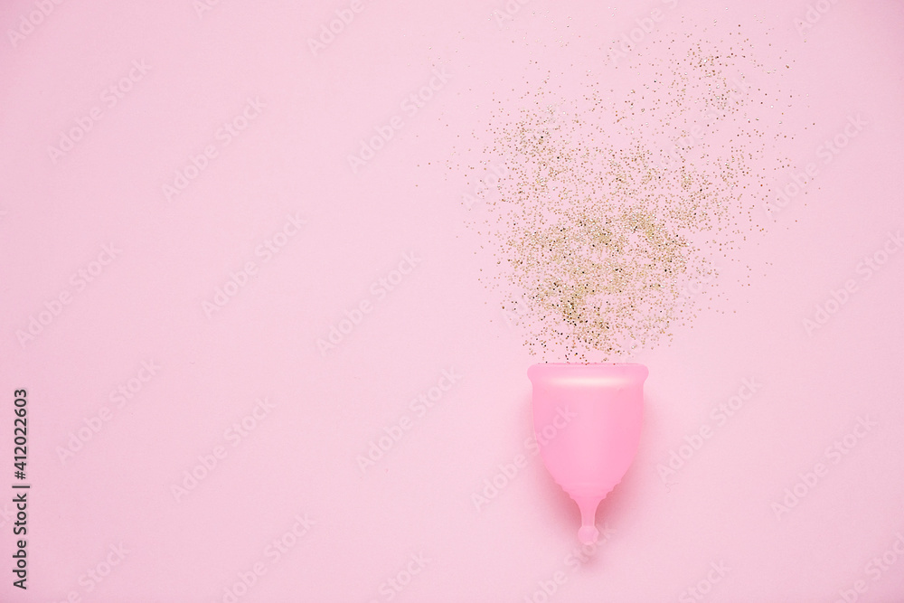 Menstrual cup with glitter on pink background. Alternative feminine hygiene product during the period. Women health concept Menstrual cup with glitter on pink background. Alternative feminine hygiene product during the period. Women health concept