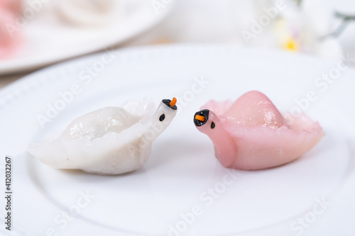 Two Chinese Har Gao Dim Sum dumplings in the shape of a swan, red and white color photo