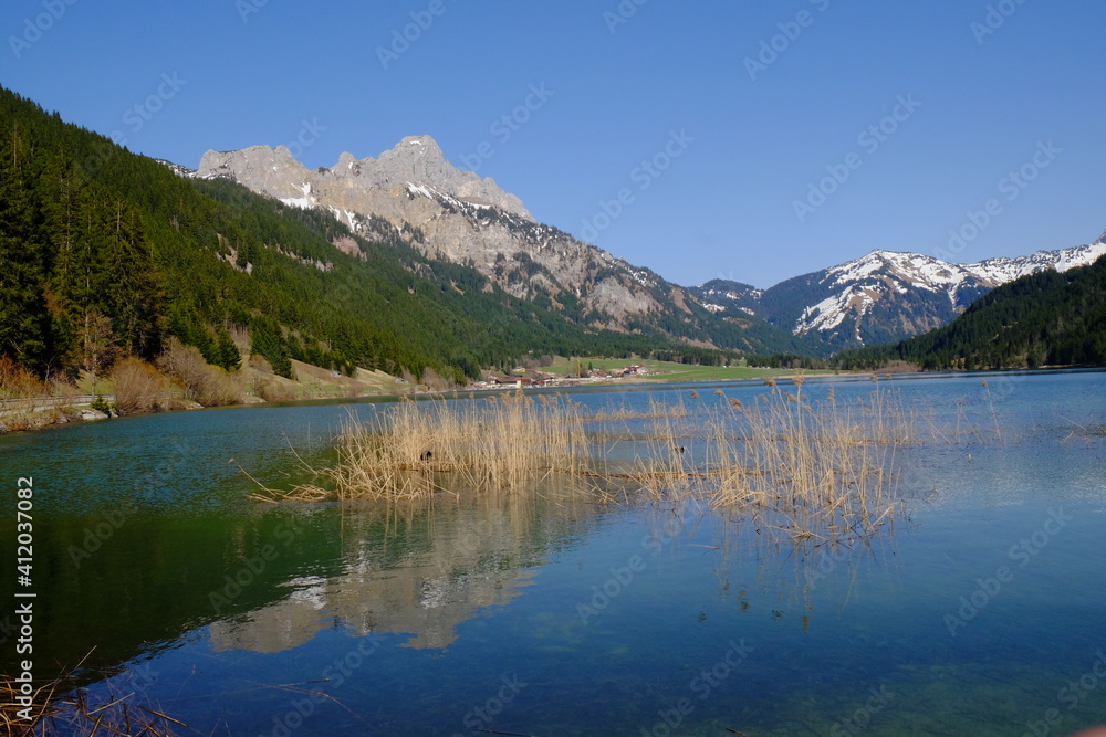 Scenic View Of Lake And Mountains Against Clear Blue Sky