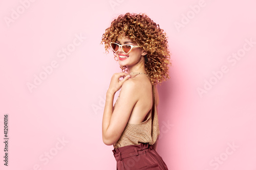 Attractive woman Curly hair smile sunglasses pink background fashion clothes 
