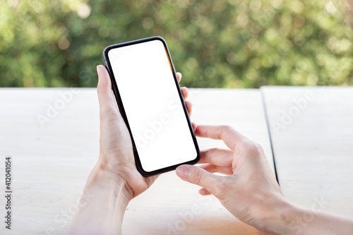 cell phone blank white screen mockup.woman hand holding texting using mobile on desk at office.background empty space for advertise.work people contact marketing business,technology © panitan