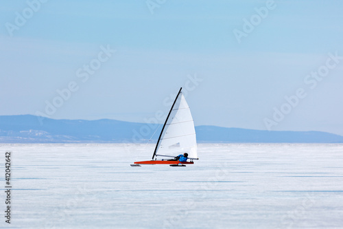 Frozen Lake Baikal. Sportsman conducts high-speed training on a ice-sailboat in a strong wind on the vast expanses of the Small Sea Strait. Active winter holidays