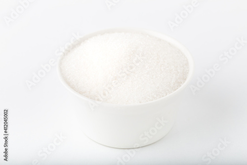 Granulated sugar. Bowl of granulated white sugar isolated on white background. 