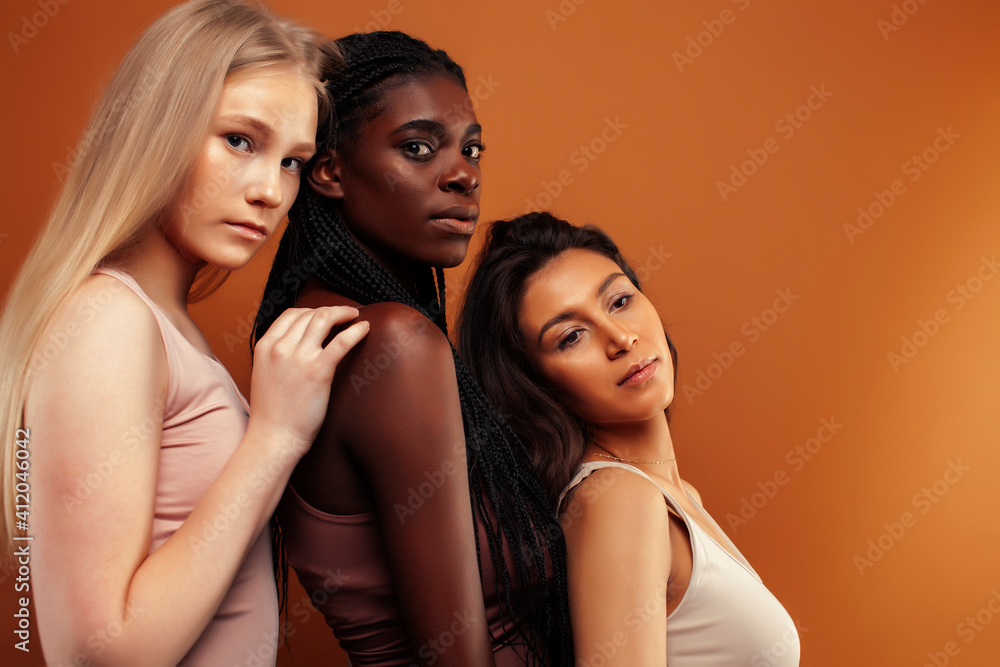 young pretty asian, caucasian, afro woman posing cheerful together on brown background, lifestyle diverse nationality people concept young pretty asian, caucasian, afro woman posing cheerful together on brown background, lifestyle diverse nationality people concept