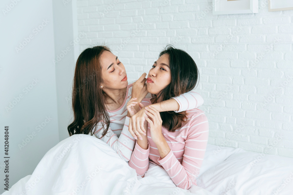 Two pretty best friends forever girlfriend talk, hug and laugh together on bed at cozy home relation fall in love. Lesbian couple homosexual happy lifestyle on bed. LGBTQ relation lifestyle concept.