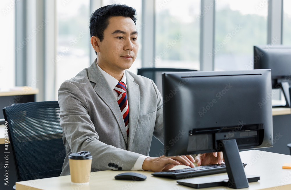 Businessman in suit sitting and working with computer in office. Businessman in suit sitting and working with computer in office.
