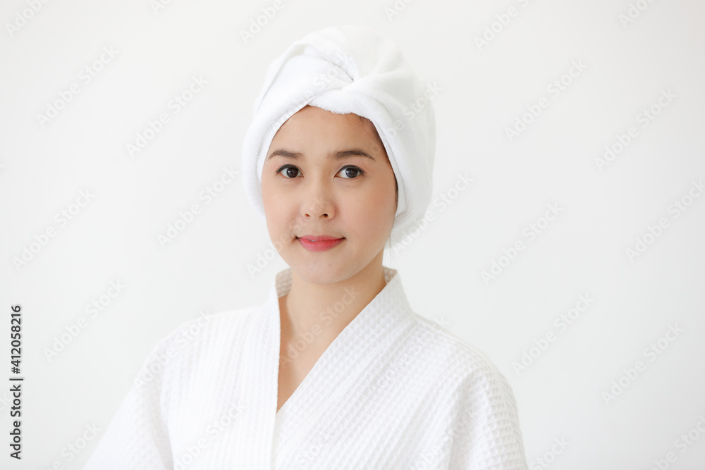 Portrait of middle age Asian woman with towel-covered around her head in the spa. She is smiling and looking at camera. Idea for female who care for health and skin Portrait of middle age Asian woman with towel-covered around her head in the spa. She is smiling and looking at camera. Idea for female who care for health and skin