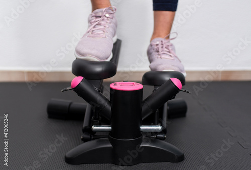 Close up front view of woman training on a stair climbers machine.