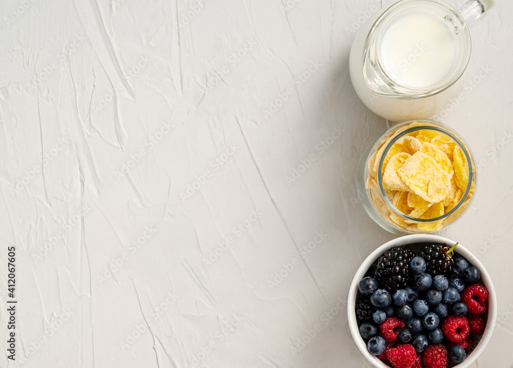 Fresh berries, cornflakes, milk - ingredients for a snack or breakfast on a white background. Fresh berries, cornflakes, milk - ingredients for a snack or breakfast on a white background.