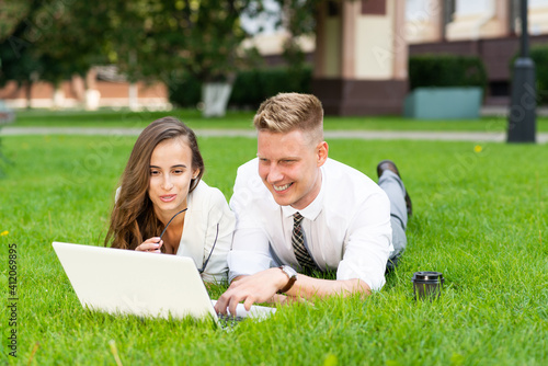 businessman and businesswoman with a laptop in a city park