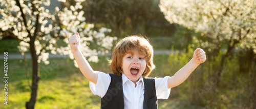 Happy child at school backyard. Blooming garden. Spring boy at park. © Volodymyr