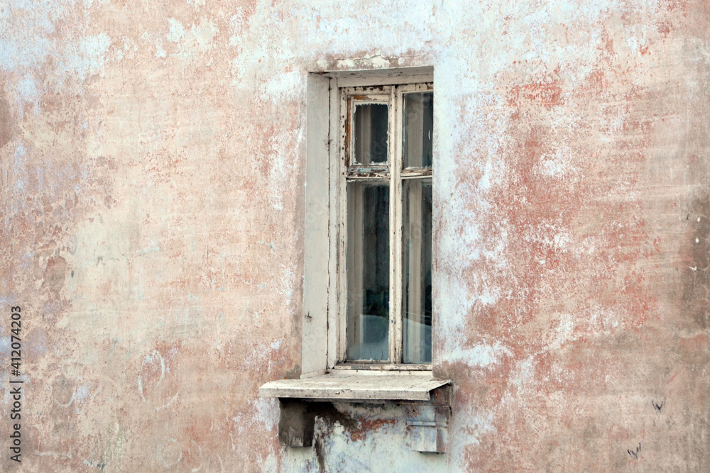 Vintage background with the texture of an old plastered damaged wall with a window. Grunge background of urban decay.