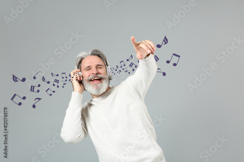 Cool senior man listening t...