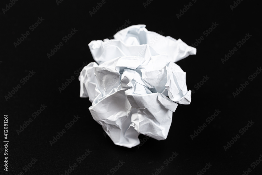 A crumpled paper ball in a black background A crumpled paper ball in a black background
