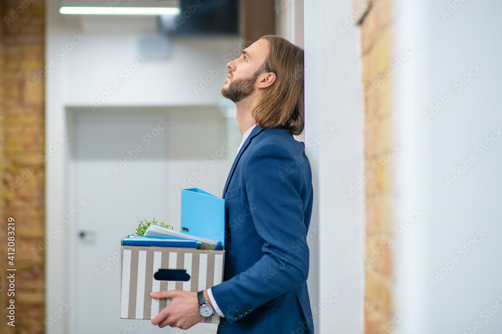 Unhappy man standing in office hallway Unhappy man standing in office hallway