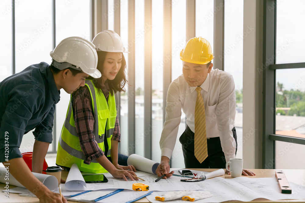 Engineer people meeting working and pointing at a drawings in office for discussing. Engineer people meeting working and pointing at a drawings in office for discussing.