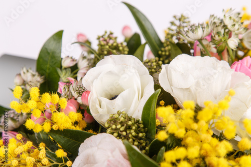 Floral arrangement with mimosa and animons on gray background 